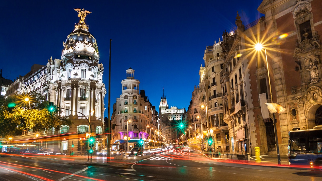 Gran Vía in Madrid illuminated at night with light trails from traffic.