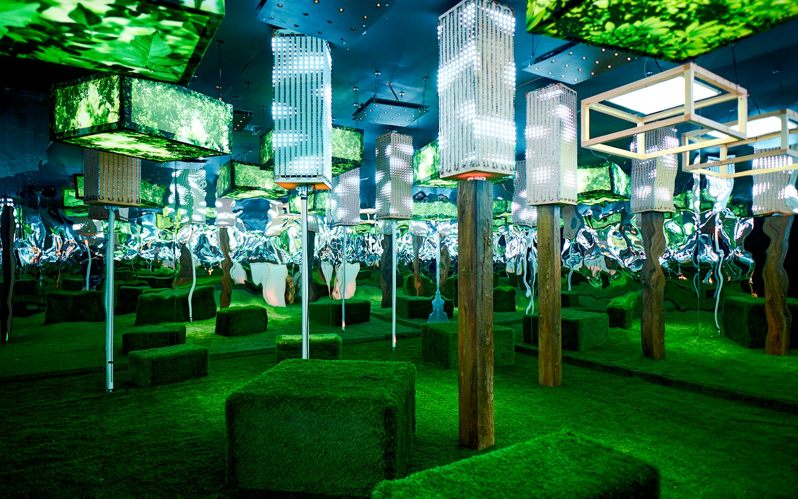 Illuminated art installation with green foliage and mirrored walls at Euphoria Grove, Dopamine Land.