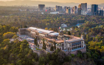 Aerial view of Chapultepec Castle surrounded by forest in Mexico City.