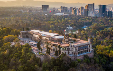 Aerial view of Chapultepec Castle surrounded by forest in Mexico City.