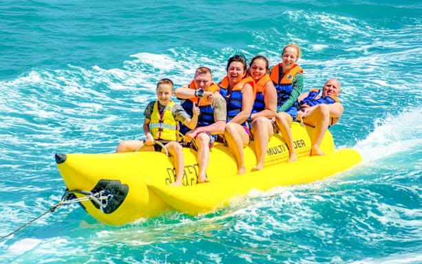 Family enjoying a banana boat ride on the ocean in Dubai.