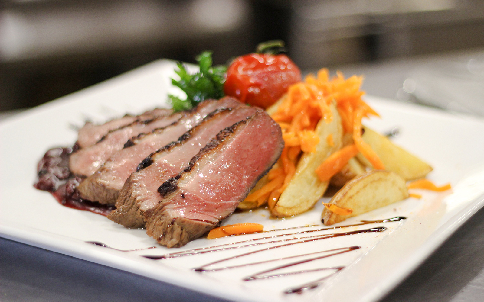 Sliced steak with roasted potatoes and carrots on Budapest Danube River Candlelit Dinner Cruise.