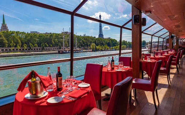 Seine River lunch cruise with Eiffel Tower view and dining setup.