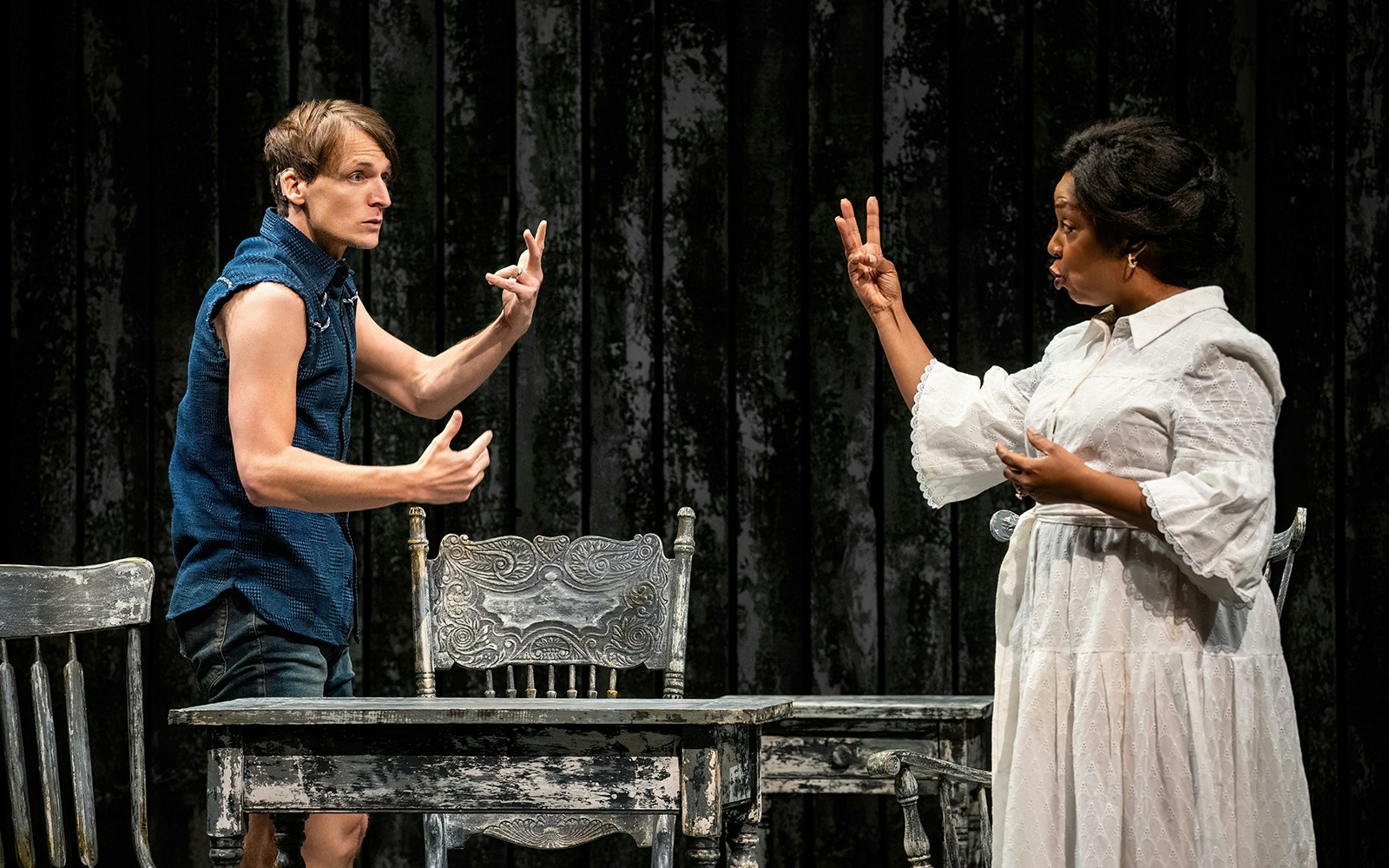 Actors performing a scene from "Our Town" on stage with vintage furniture.