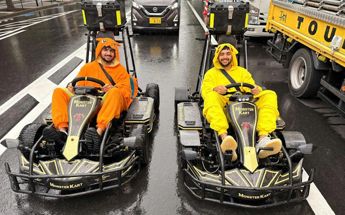 Two people in costumes driving go-karts on a street during the Asakusa Electric Go Kart 120 min Tour.