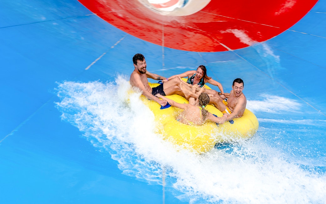 Friends enjoying a water slide ride at a water park.