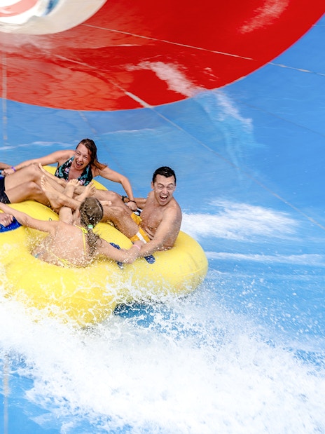 Friends enjoying a water slide ride at a water park.