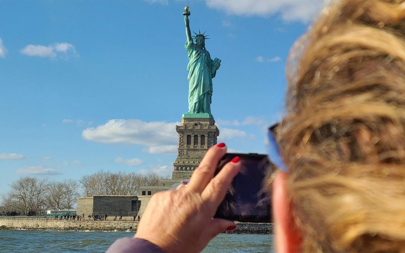 Statue of Liberty and Ellis Island cruise with New York City skyline in the background.