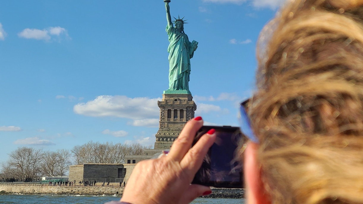 Statue of Liberty and Ellis Island cruise with New York City skyline in the background.