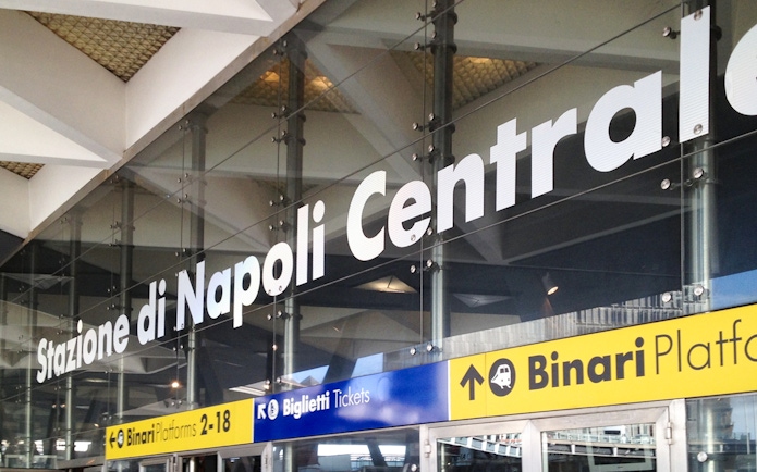 Naples Central Station entrance signage for train platforms and ticketing.