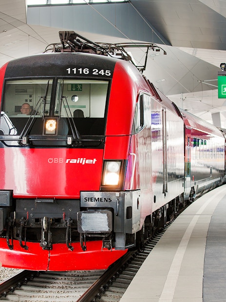 Red ÖBB Railjet train at a modern station platform, part of the Eurail Global Flexible Pass experience.