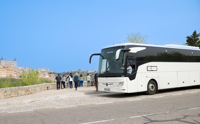 Tour group near Toledo Express bus with view of Toledo, Spain.