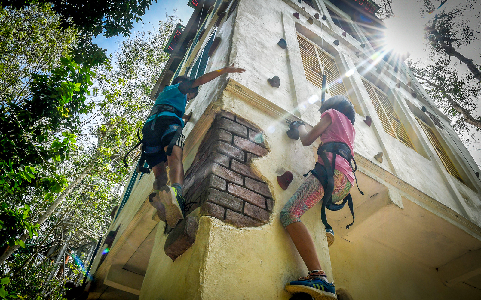 Visitors climbing the ESCAPE Penang Gecko Tower in Malaysia, showcasing the adventure park's unique vertical challenge.