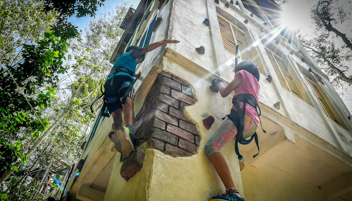 Visitors climbing the ESCAPE Penang Gecko Tower in Malaysia, showcasing the adventure park's unique vertical challenge.