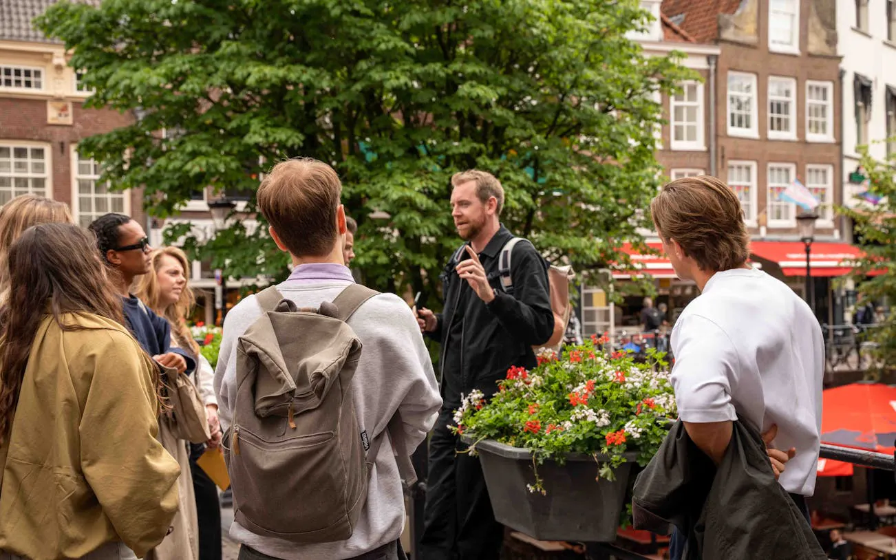 Group listening to guide during Utrecht walking tour with local stories.