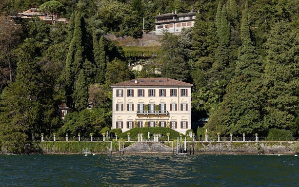 Villa del Balbianello on Lake Como surrounded by lush greenery and overlooking the water.