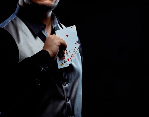 Magician holding a fan of playing cards during a trick.