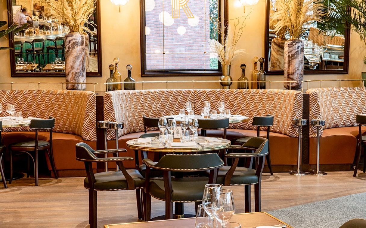Brasserie Rosalie dining area with set tables and patterned seating.