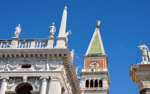 St. Mark’s Bell Tower with statues and architectural details in Venice, Italy.