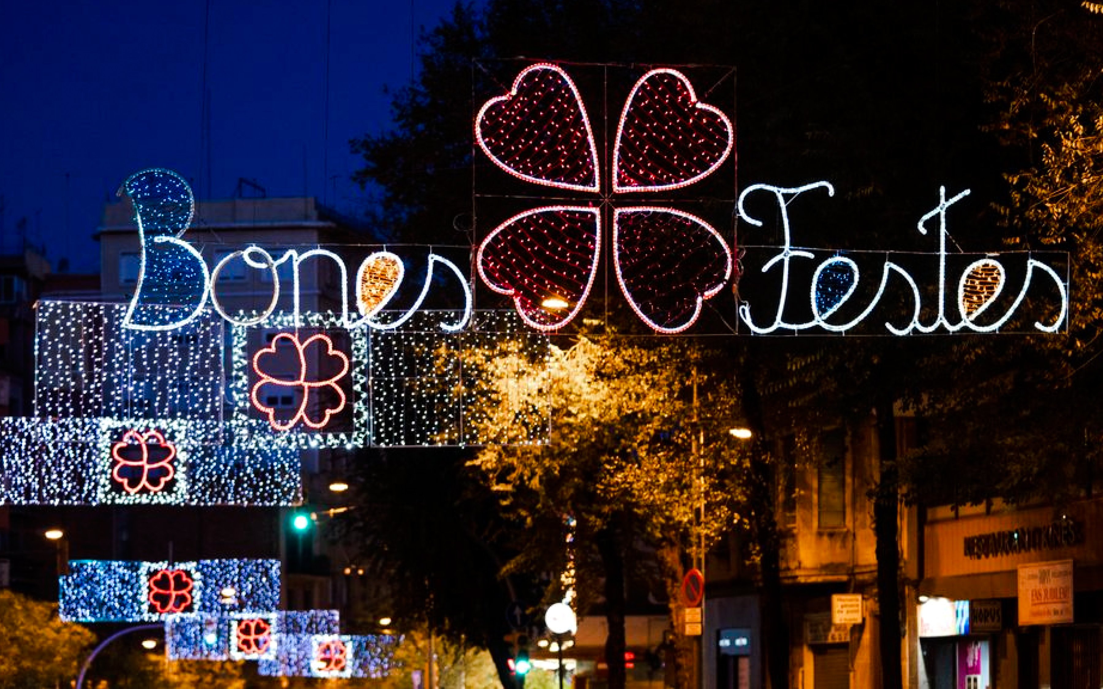 Barcelona street with festive Christmas lights and "Bones Festes" sign.