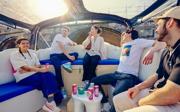Guests enjoying the Cloud Boat Cruise in Amsterdam under a sunny sky.