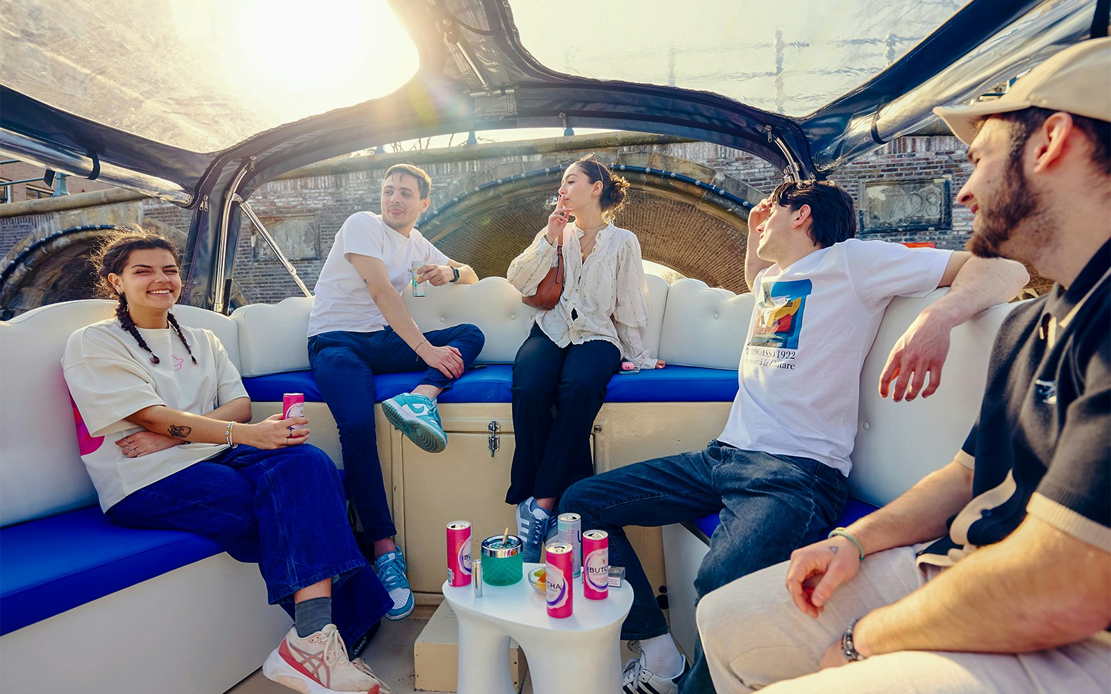 Guests enjoying the Cloud Boat Cruise on Amsterdam's canals with cityscape views.