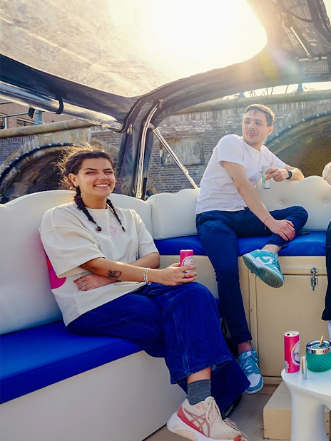 Guests enjoying the Cloud Boat Cruise in Amsterdam under a sunny sky.