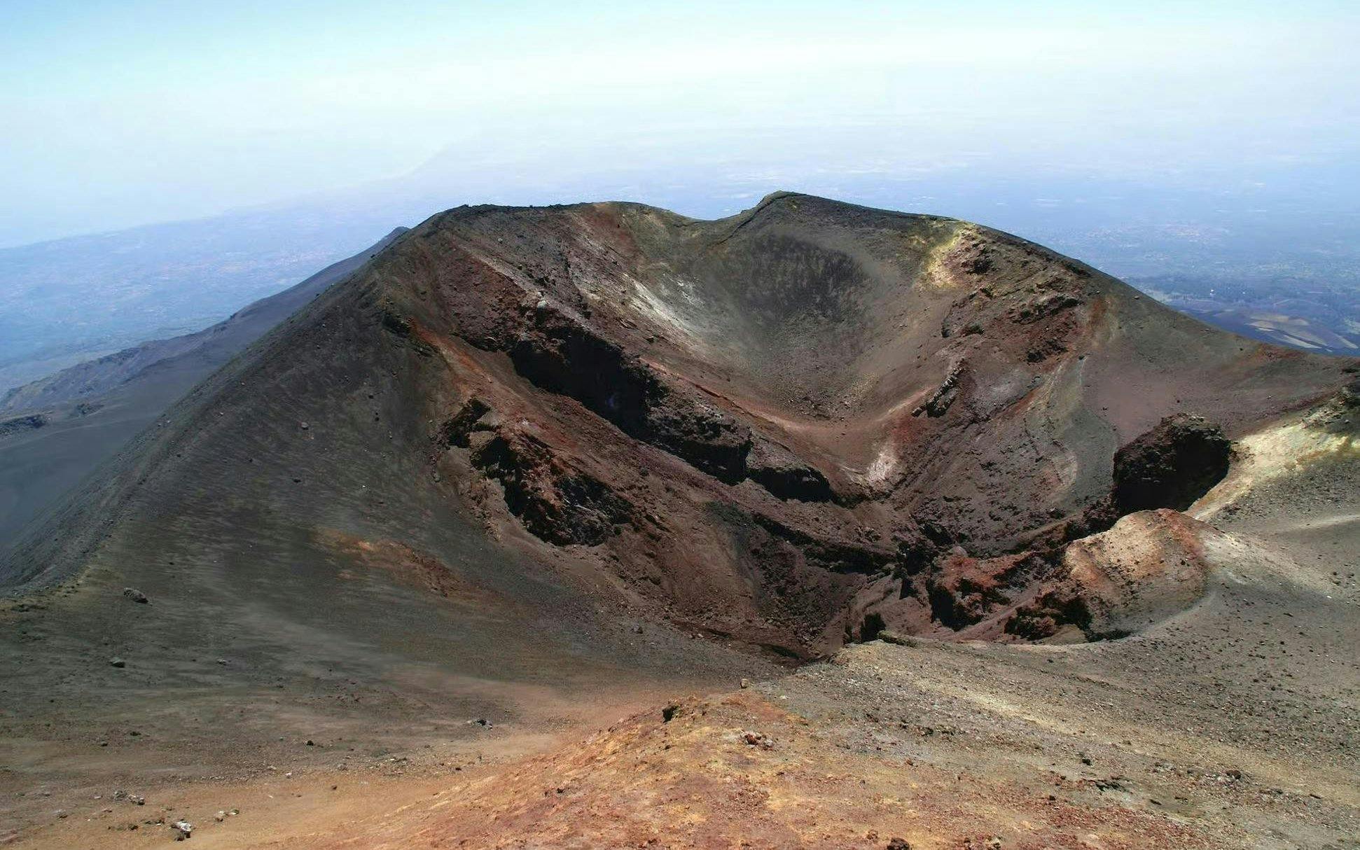 Crater of Mount Etna in Sicily with surrounding volcanic landscape.