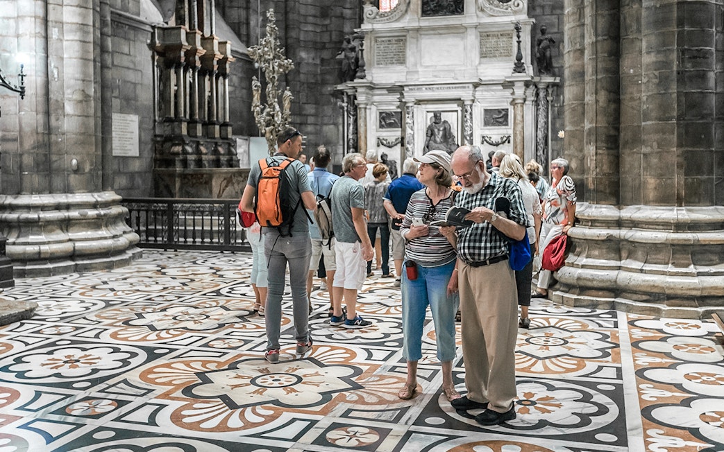 Tourists exploring the interior of Duomo Cathedral, Milan.
