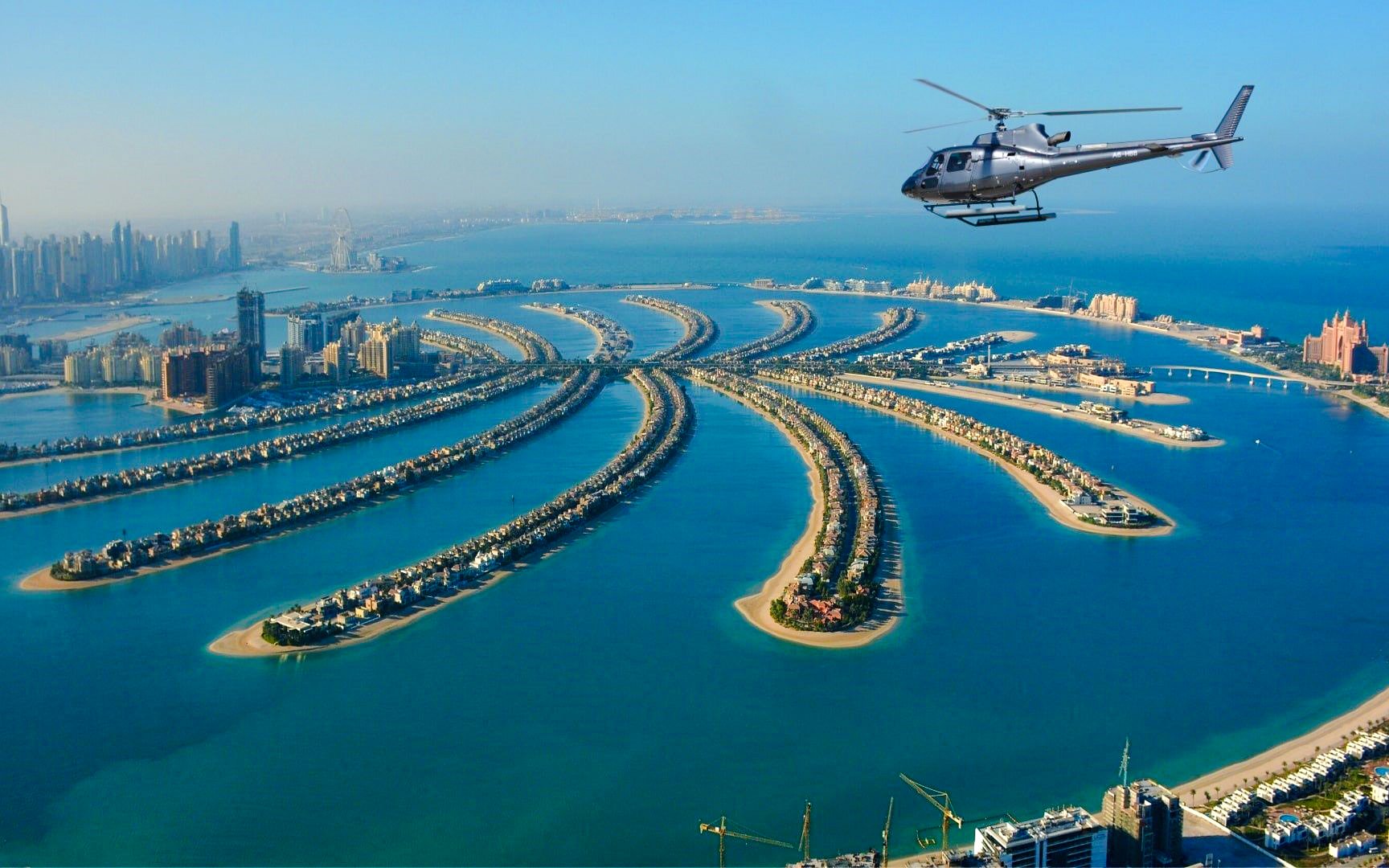 Helicopter flying over Palm Jumeirah, Dubai, showcasing the iconic palm-shaped islands.