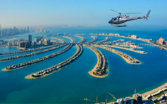 Helicopter flying over Palm Jumeirah, Dubai, showcasing the iconic palm-shaped islands.