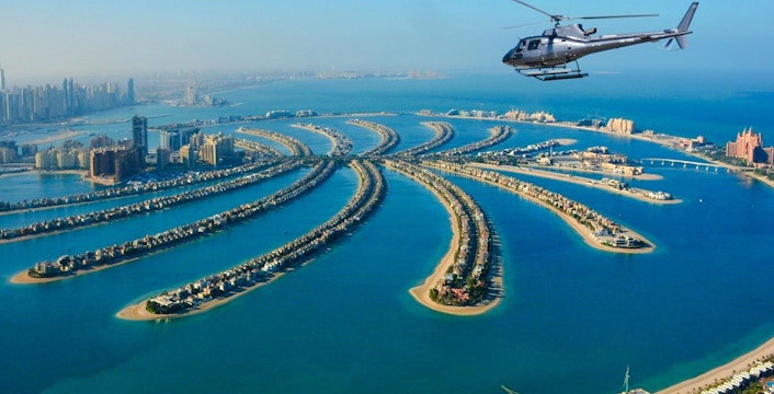 Helicopter flying over Palm Jumeirah, Dubai, showcasing the iconic palm-shaped islands.