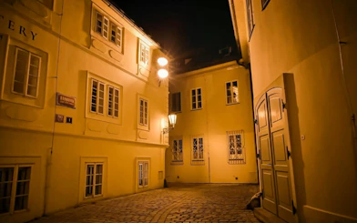 Old Town Prague alley at night, illuminated by street lamps, part of Ghosts & Legends tour.