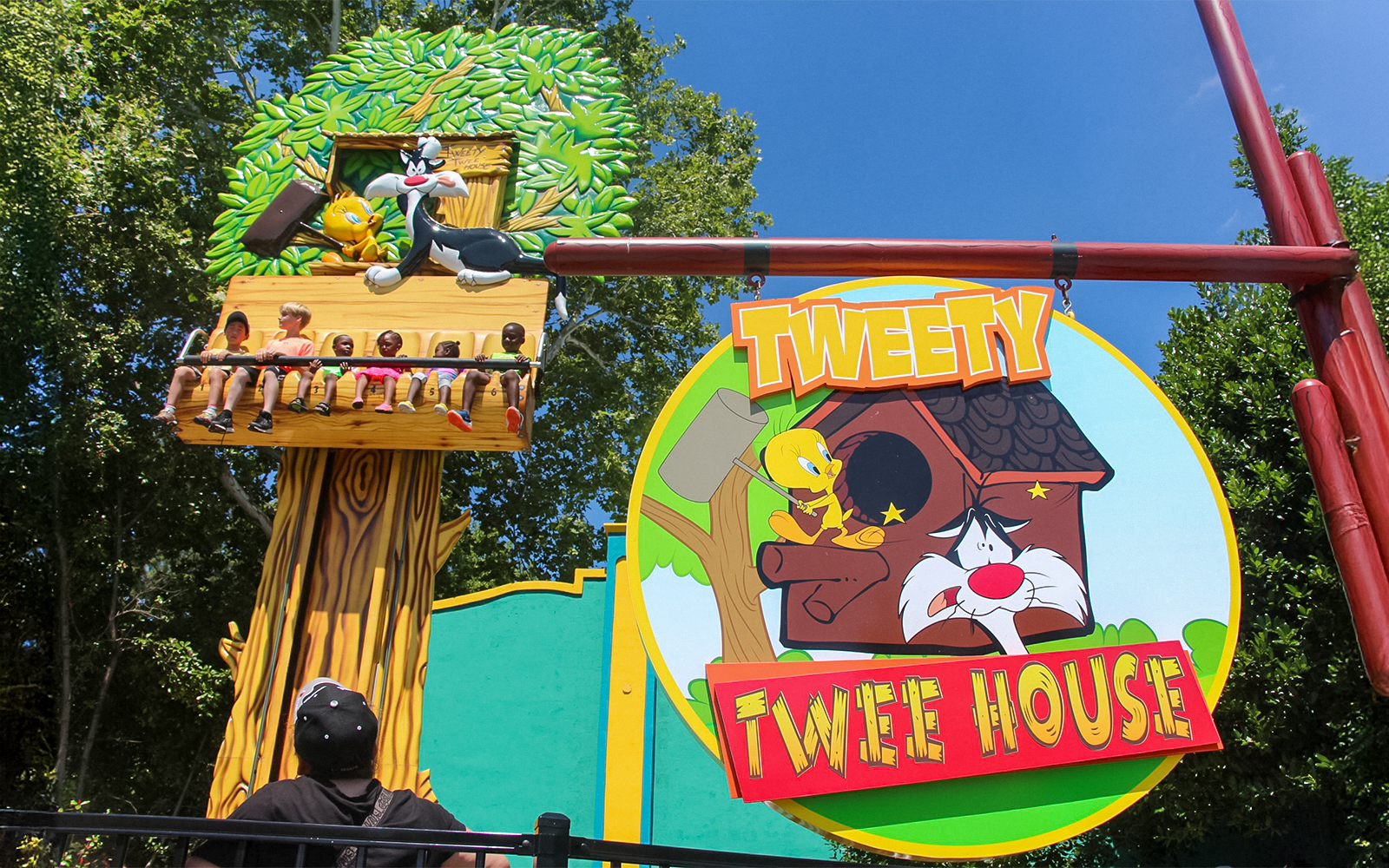 Tweety and Sylvester ride at Six Flags Over Georgia with children enjoying the attraction.
