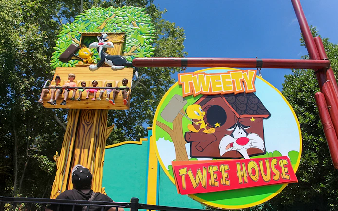 Tweety and Sylvester ride at Six Flags Over Georgia with children enjoying the attraction.