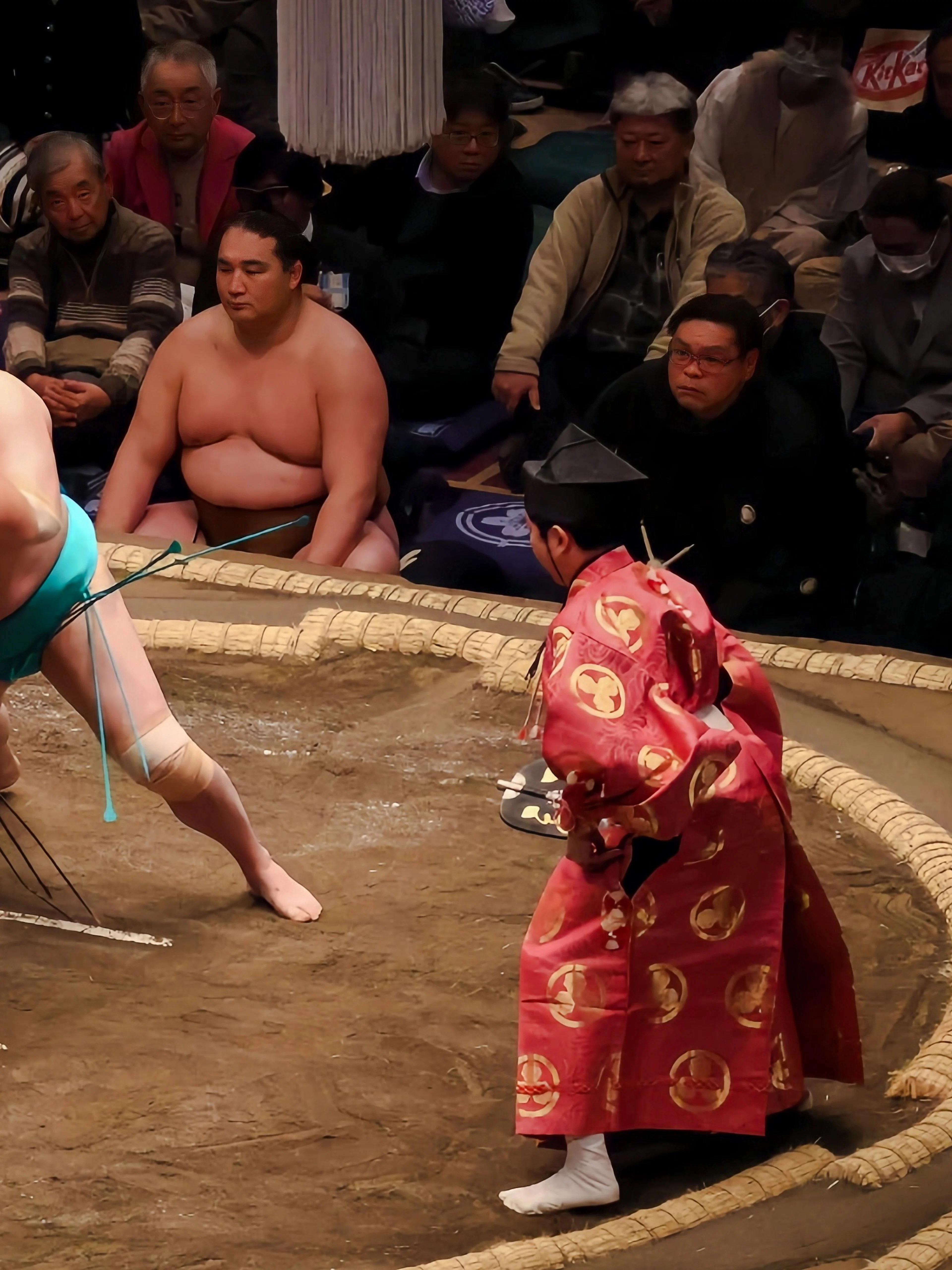 Sumo wrestlers grappling in a traditional ring during a match in Japan.