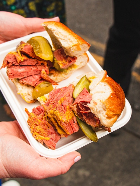 Pastrami sandwich with pickles on a food tour in Brick Lane, London.