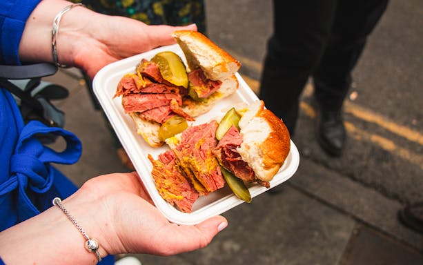 Pastrami sandwich with pickles on a food tour in Brick Lane, London.