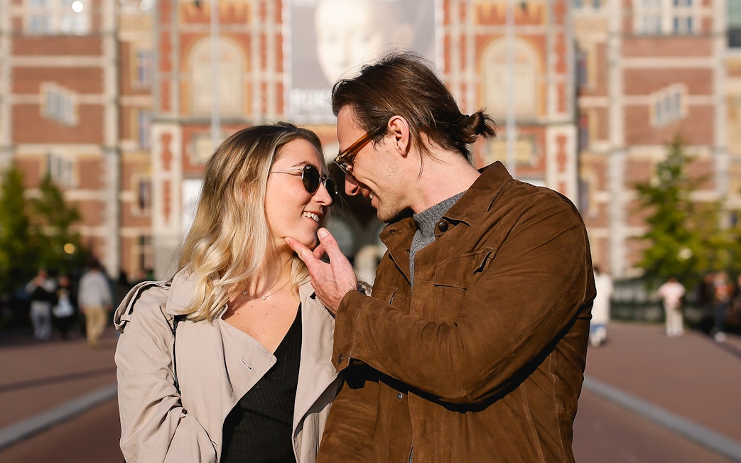 Couple posing in front of the Rijksmuseum during a professional photoshoot in Amsterdam.