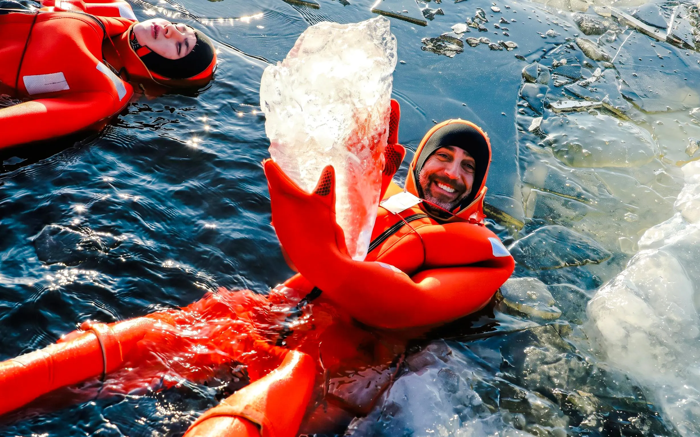 Guests in red suits enjoying ice floating on Icebreaker Cruise.