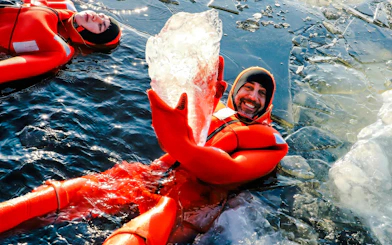 Guests in red suits enjoying ice floating on Icebreaker Cruise.