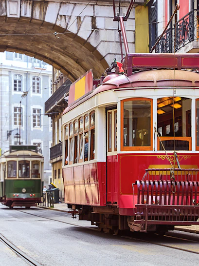 Tramcar passing under arch in Alfama district, Lisbon.