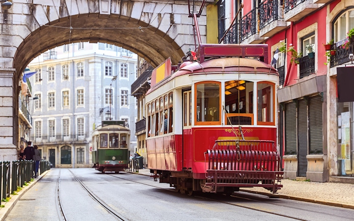Tramcar passing under arch in Alfama district, Lisbon.