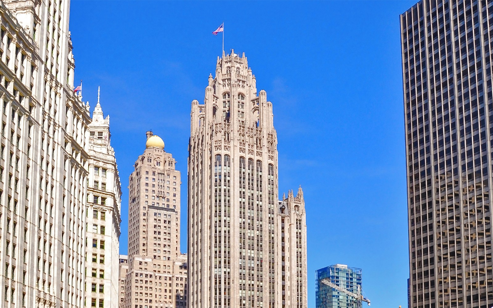Tribune Tower in Chicago with surrounding skyscrapers against a clear blue sky.