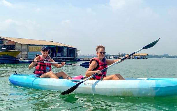 Kayakers paddling near floating houses at Pulau Ubin, Singapore.