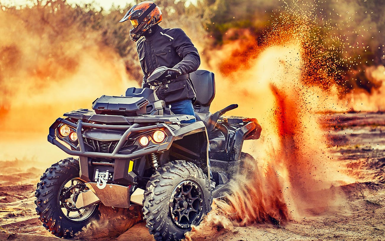 Quad bike kicking up sand on a guided tour in Bosa.