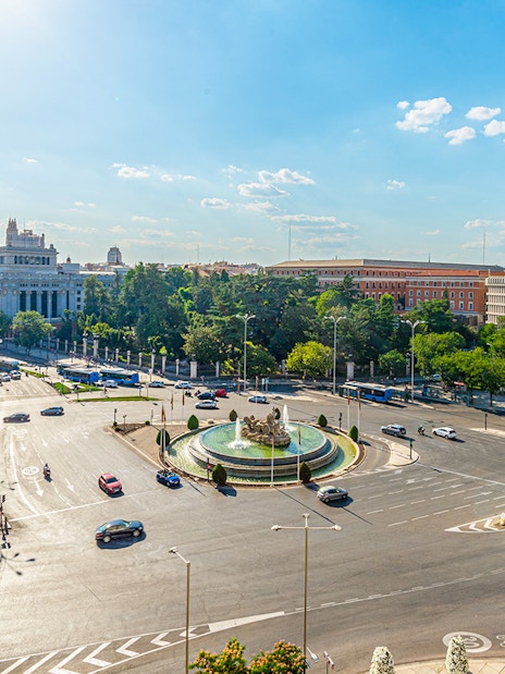 Cibeles fountain and Madrid traffic viewed from City Hall, with Paseo del Prado in the background.