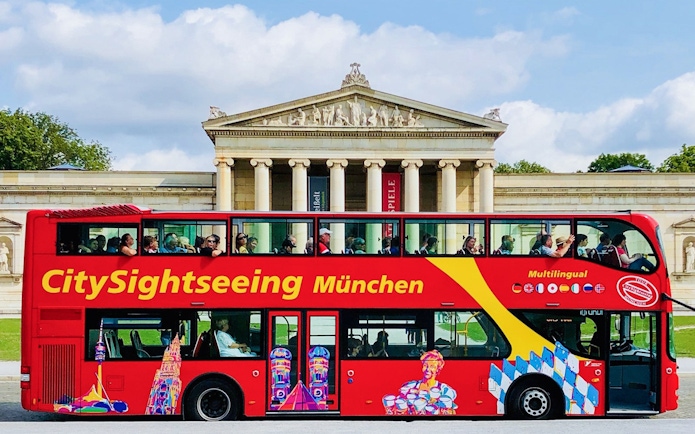 CitySightseeing bus in front of Munich's neoclassical building.