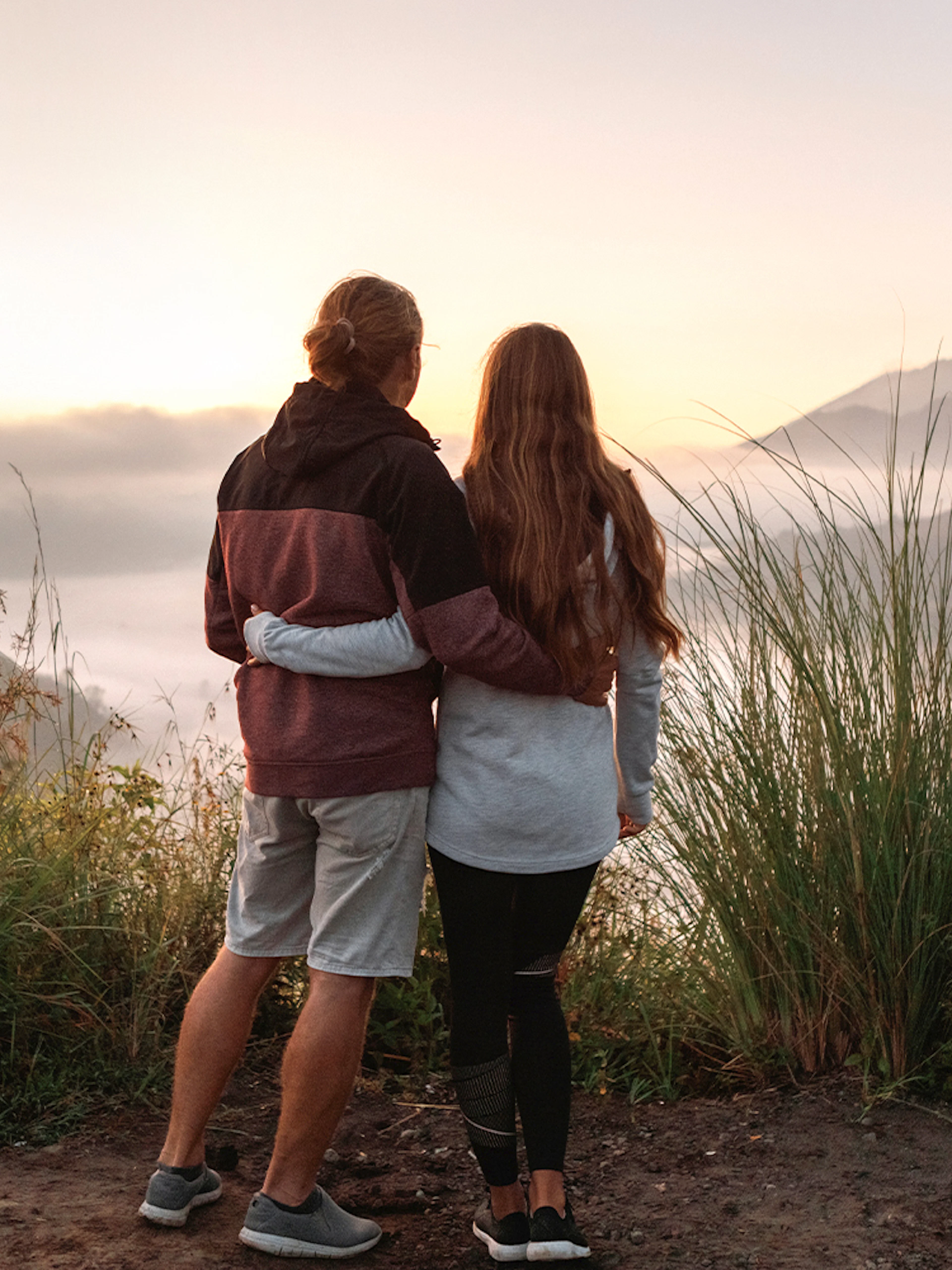 Couple viewing Mount Batur during sunrise trek in Bali.