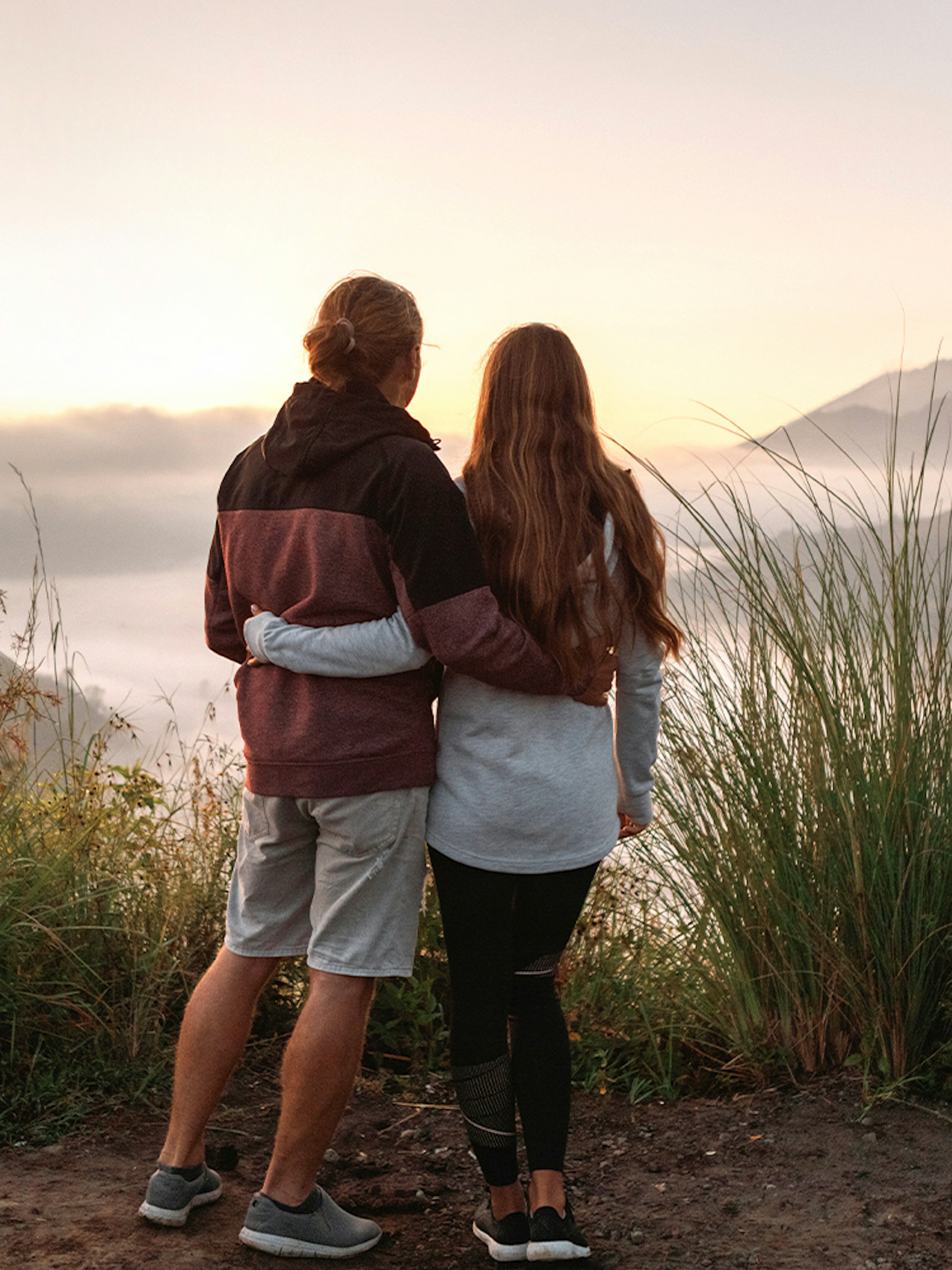 Couple viewing Mount Batur during sunrise trek in Bali.